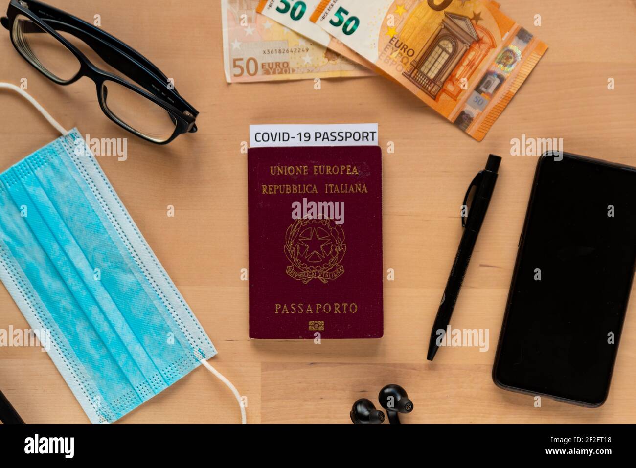concept of business travel with covid vaccination passport with covid19 immunity passport. hand sanitizer and mobile phone and money with face mask, t Stock Photo