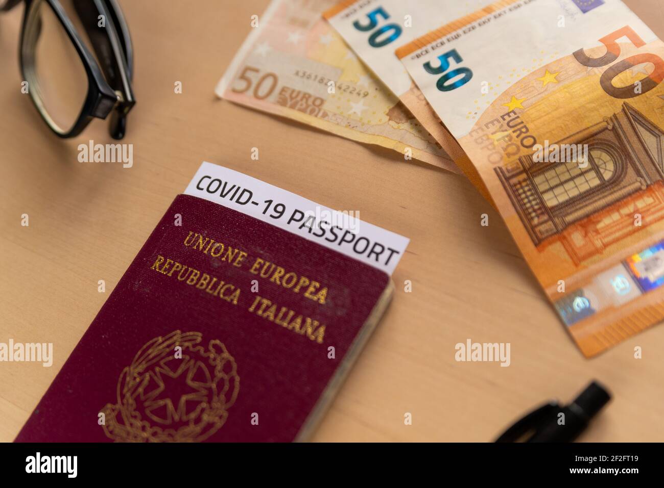 concept of business travel with covid vaccination passport with covid19 immunity passport. hand sanitizer and mobile phone and money with face mask, t Stock Photo