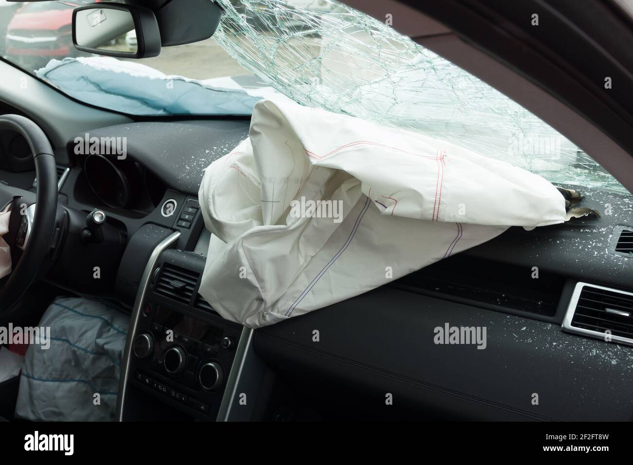 Interior of a automobile or car involved in a vehicle crash with a deployed passenger side airbag Stock Photo
