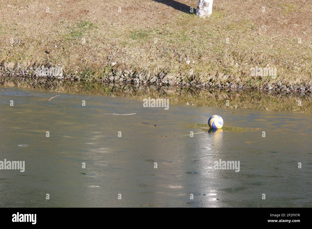 Ball Floating on Frozen River at park Stock Photo