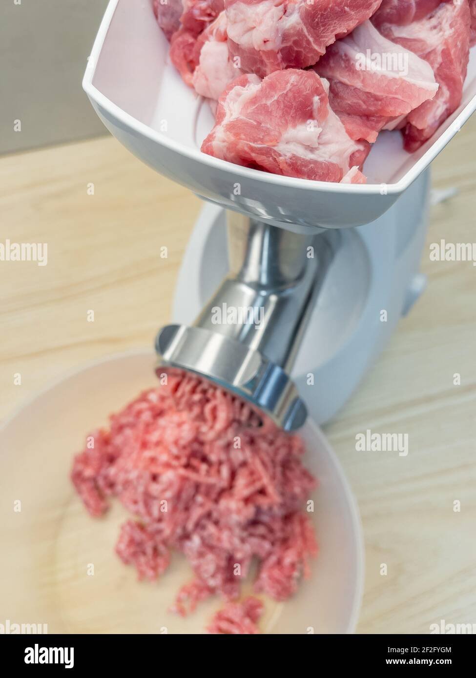 Meat grinder. Making homemade raw minced meat at kitchen. Close up of fatty  pork minced Stock Photo - Alamy