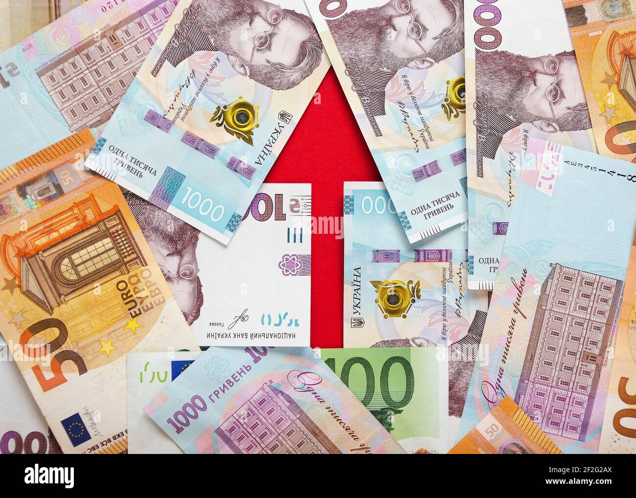 An arrow lined with banknotes of Ukrainian hryvnias and euros 3 Stock Photo