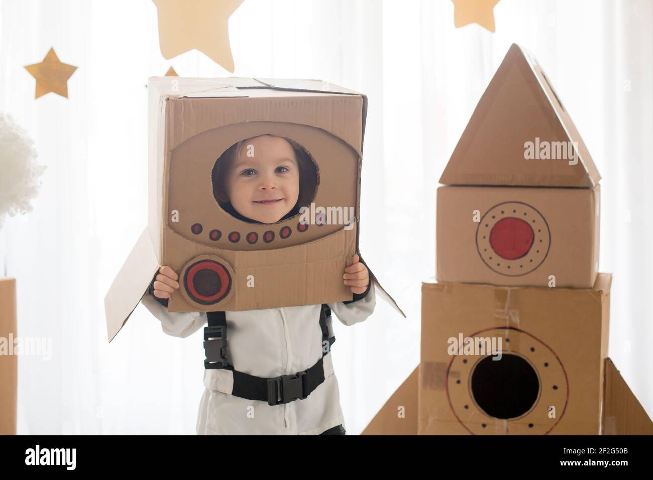 Sweet toddler boy, dressed as an astronaut, playing at home with ...