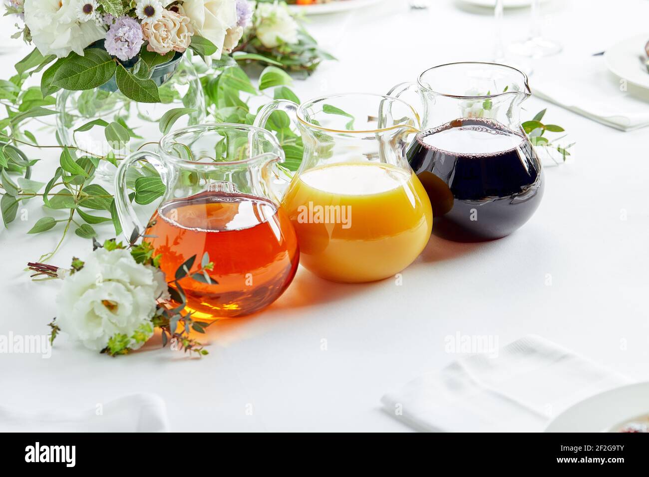 https://c8.alamy.com/comp/2F2G9TY/jugs-with-different-juices-on-event-catering-apple-orange-cherry-and-tomato-juices-2F2G9TY.jpg