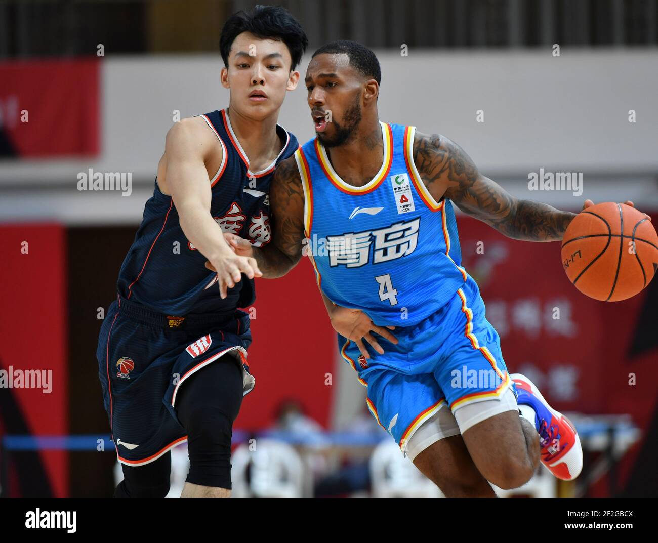 Zhuji, China's Zhejiang Province. 12th Mar, 2021. Darius Adams (R) of  Qingdao Eagles dribbles during the 45th round match between Qingdao Eagles  and Guangdong Southern Tigers at the 2020-2021 season of the