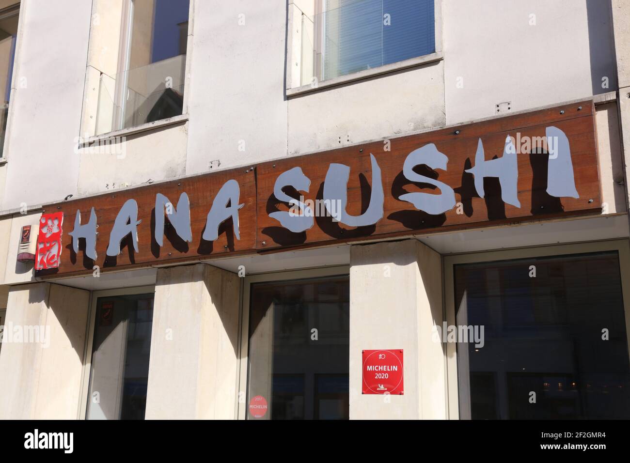 Cracow. Krakow. Poland. Hana Sushi korean and japanese restaurant signboard on the facade. Red sign of The Michelin Plate: Good cooking Michelin Recco Stock Photo