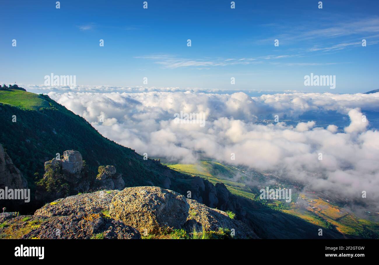 Meadow in the mountains over the clouds Stock Photo