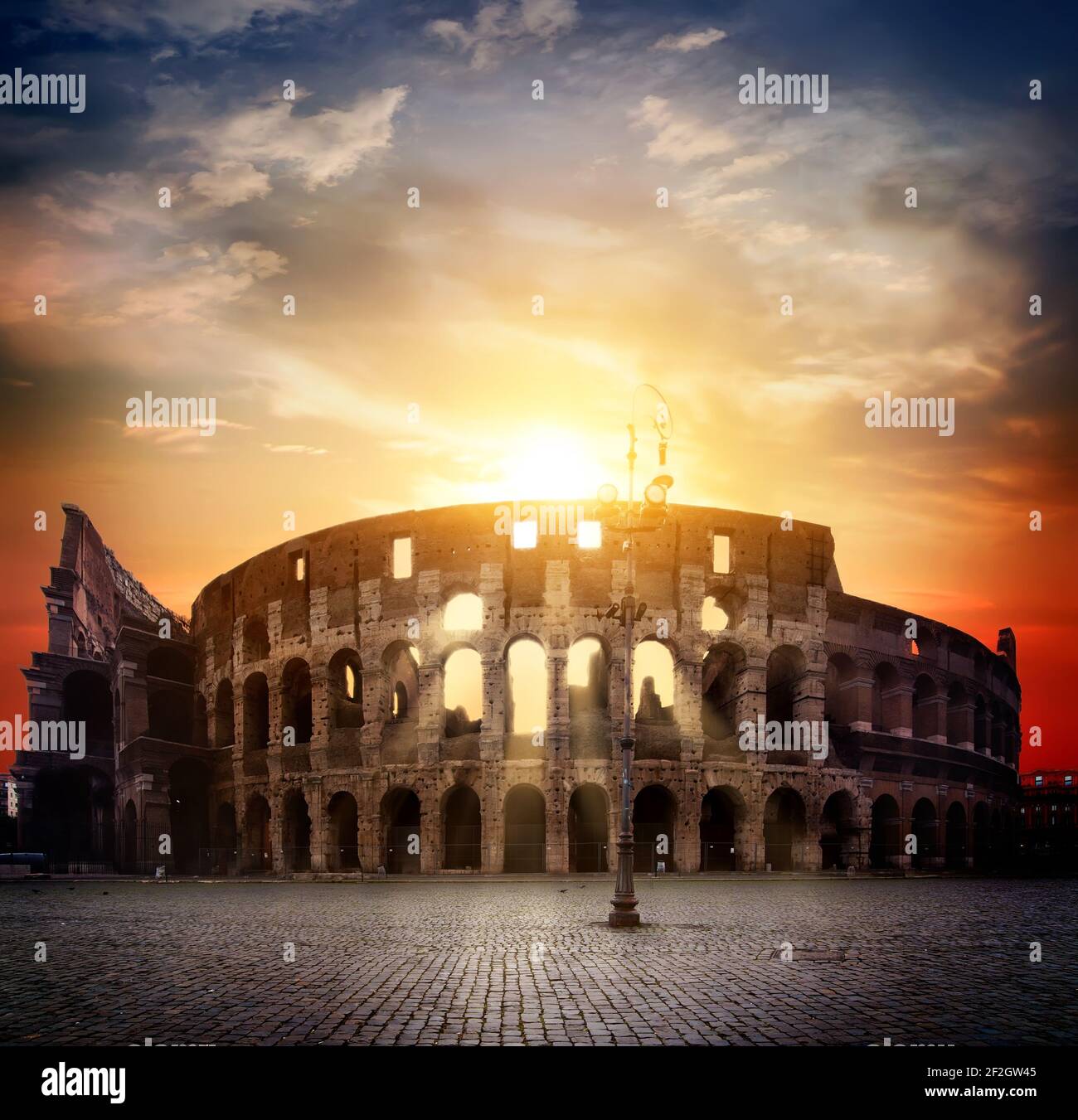 Ancient roman colosseum and sunny sunrise in Rome, Italy Stock Photo
