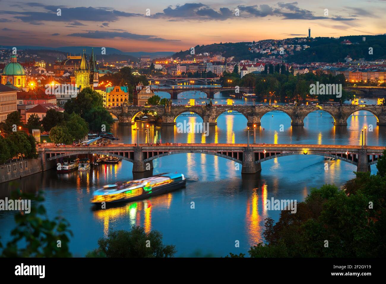 Illuminated bridges in Prague on river Vltava at sunset Stock Photo