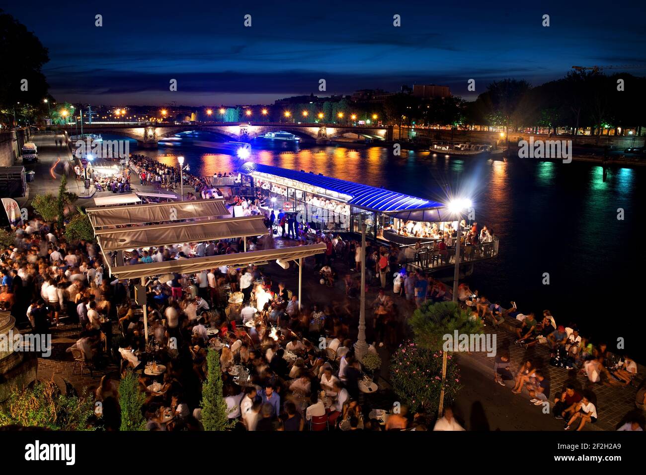 PARIS, FRANCE - AUGUST 25, 2016. Parisian summer cafe on the bank of river Seine at night, France Stock Photo