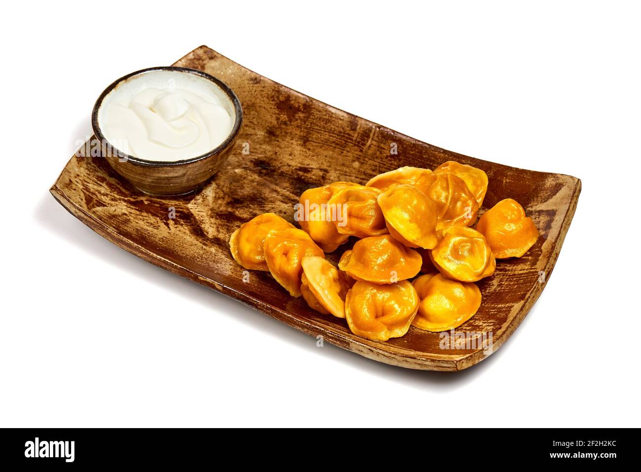 Yellow dim sum on a wooden plate on a white background. Stock Photo