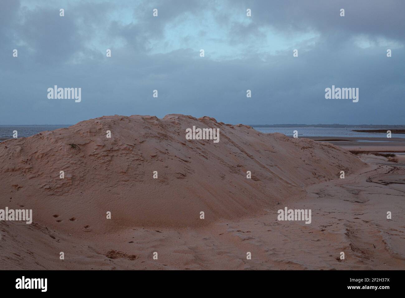 A sandy beach under a cloudy sky on a gloomy day Stock Photo - Alamy