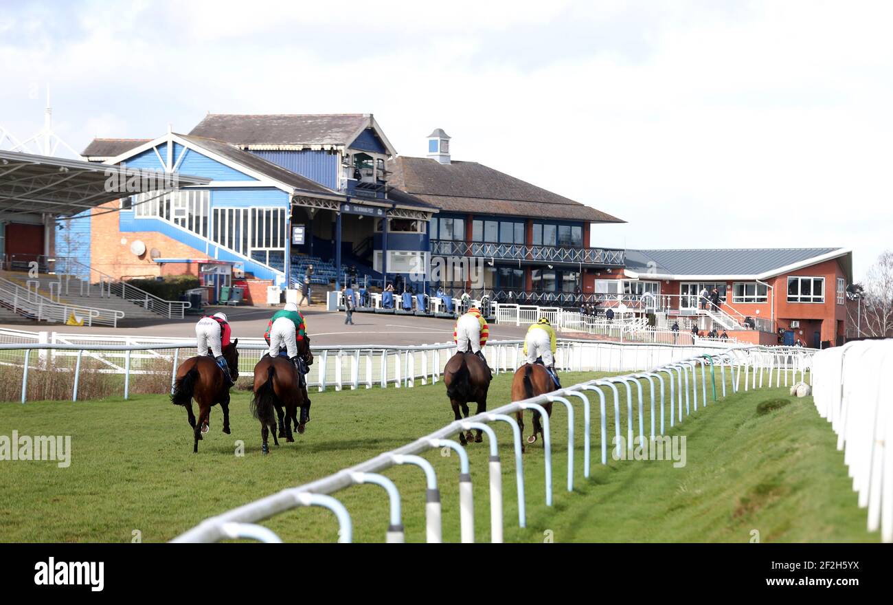 Runner And Riders Head Towards The Empty Grandstand During The Racing runner-and-riders-head-towards-the-empty-grandstand-during-the-racing