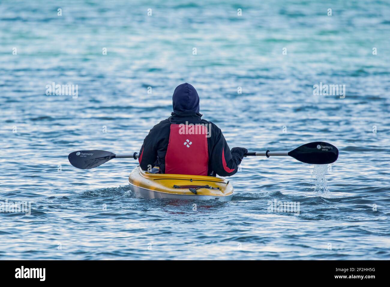 A man in a kayak enjoying a very early season paddle along the Sturgeon Bay Shipping canal located in Door County Wi. An example of proper safety gear Stock Photo
