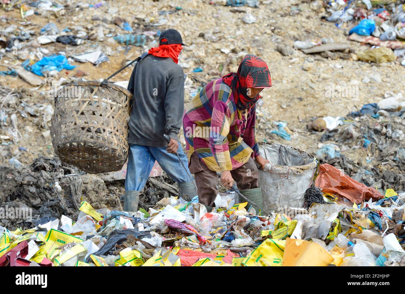 LHOKSEUMAWE, ACEH, INDONESIA - 2018/09/21: scavengers are seen looking for plastic bottle trash at a garbage dump in Lhokseumawe. Stock Photo
