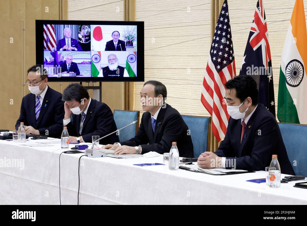 Tokyo, Japan. 12th Mar, 2021. Yoshihide Suga (C) Japanese Prime Minister speaks while a monitor displays U.S. President Joe Biden, Scott Morrison, Australia's Prime Minister, and Narendra Modi, India's Prime Minister, during the Japanese PM attends Virtual Quadrilateral Security Dialogue (Quad) meeting at his official residence in Tokyo, Japan, on Friday, March 12, 2021. Credit: POOL/ZUMA Wire/Alamy Live News Stock Photo