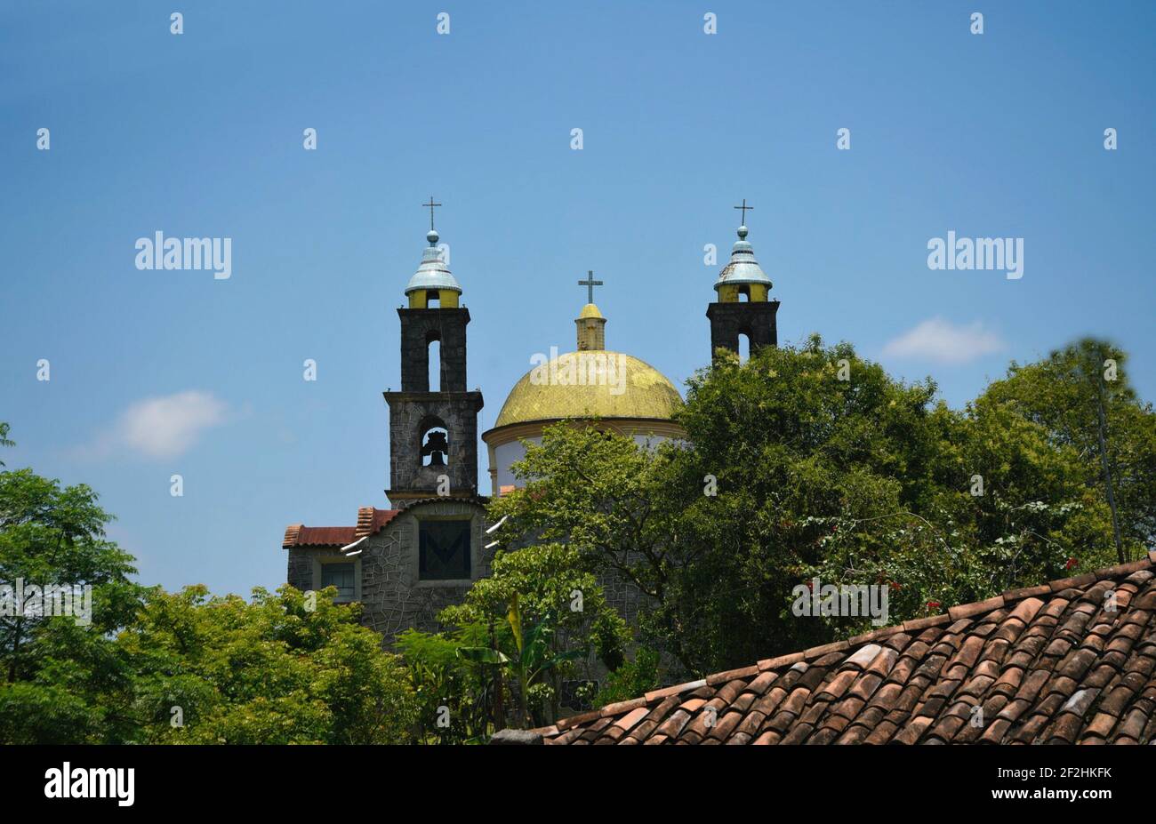 Dome and clock tower view of the Capilla De La Virgen De Guadalupe, a historic landmark of Xochitlán De Vicente Suárez in Puebla, Mexico. Stock Photo