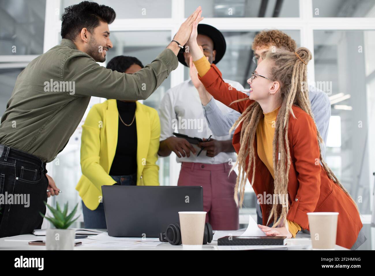 Mixed race people giving high five after successful meeting Stock Photo ...