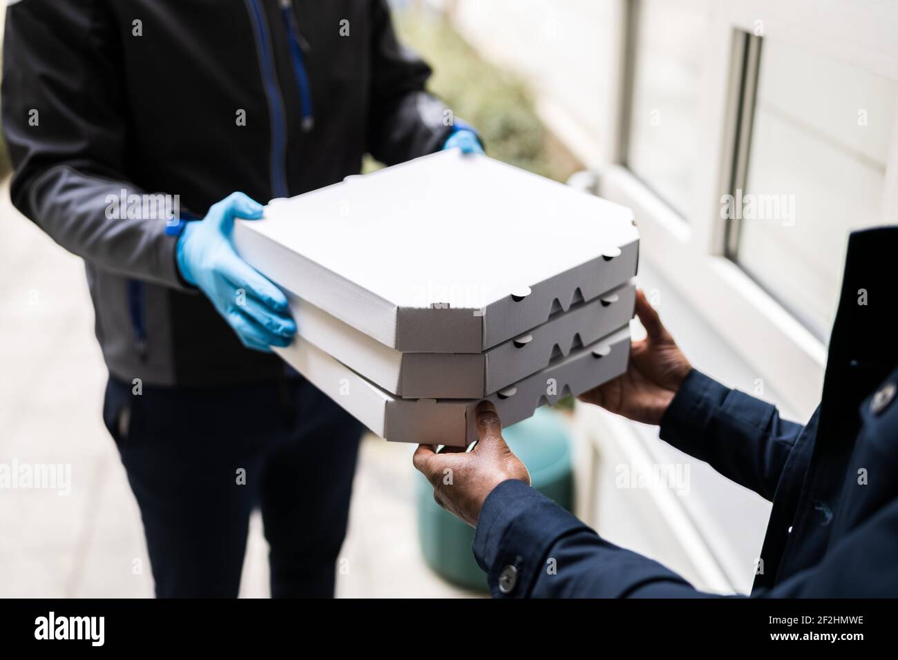 Receiving Pizza From Delivery Man In Face Mask At Home Stock Photo - Alamy