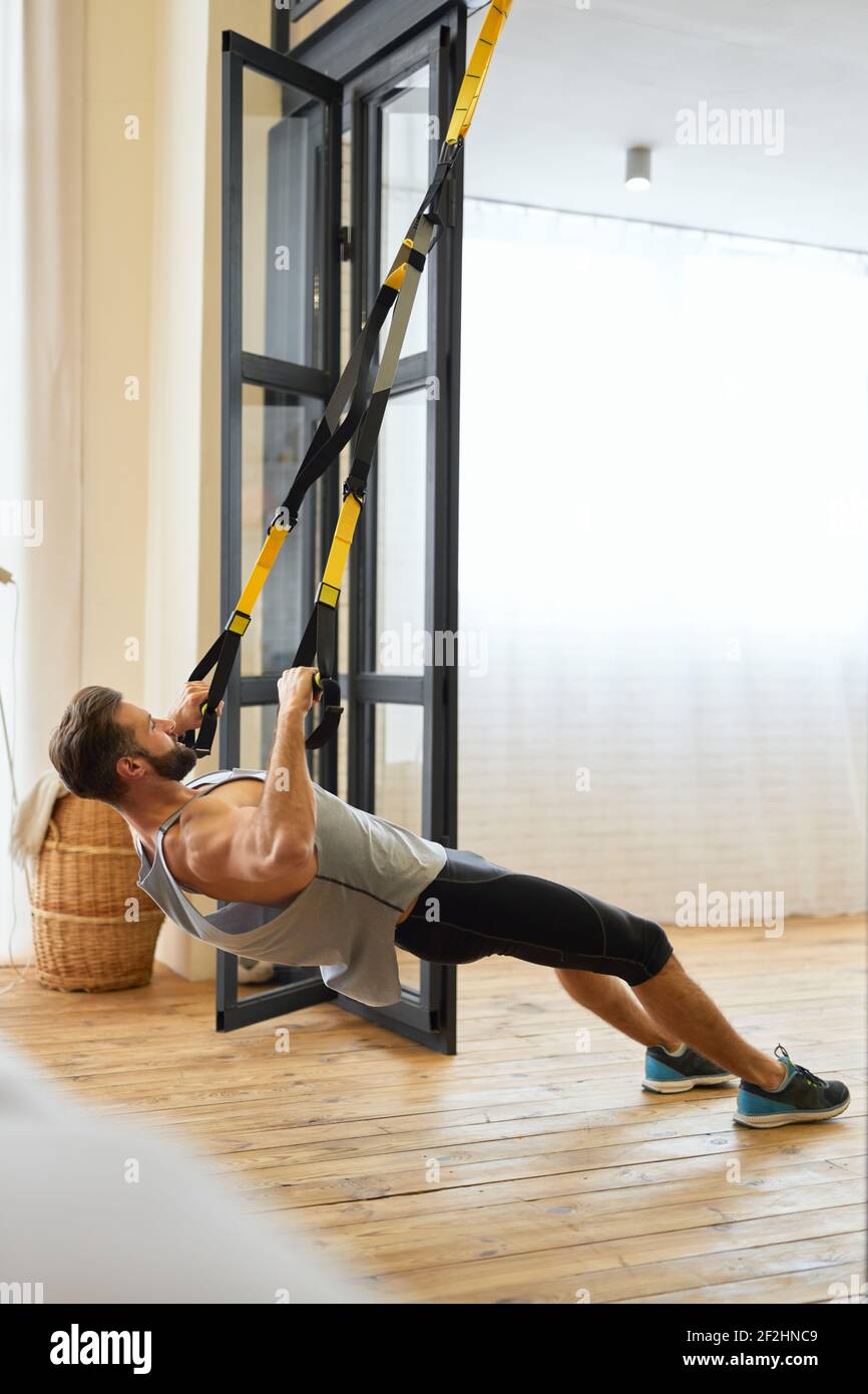 Man Using Strength Male bodybuilder doing exercise resistance hi-res stock photography and ...