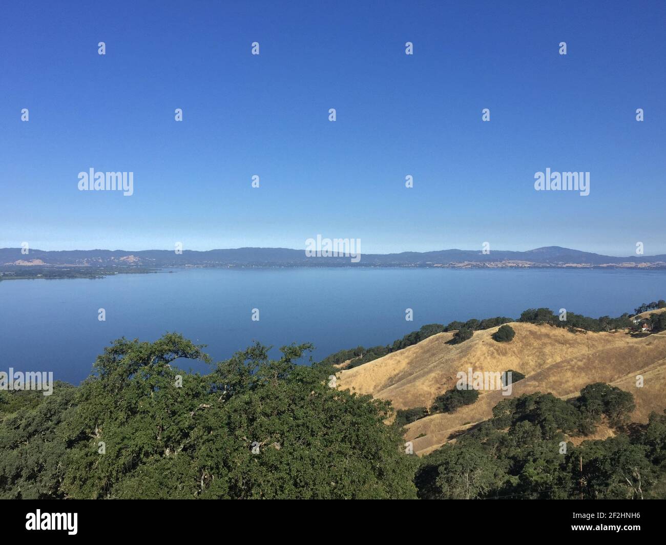 A breathtaking view of a lake surrounded by mountains under a clear ...