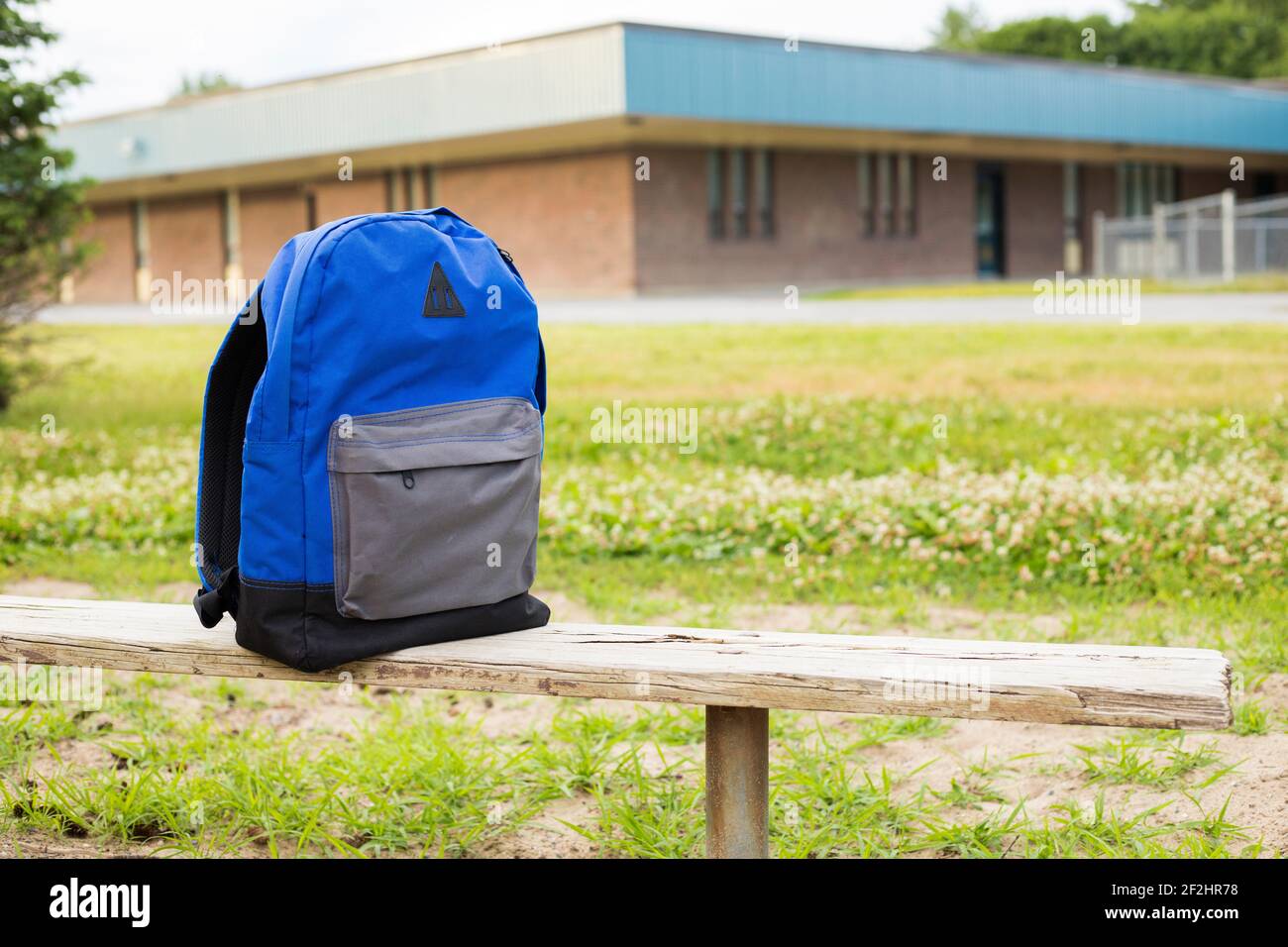 Backpack on bench near school in the park. Back to school concept Stock