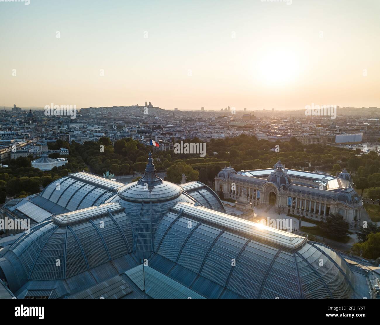 Aerial morning closeup over Grand Palais museum with sun glare/reflection on glass roof and Petit Palais in right backdrop with city view Stock Photo