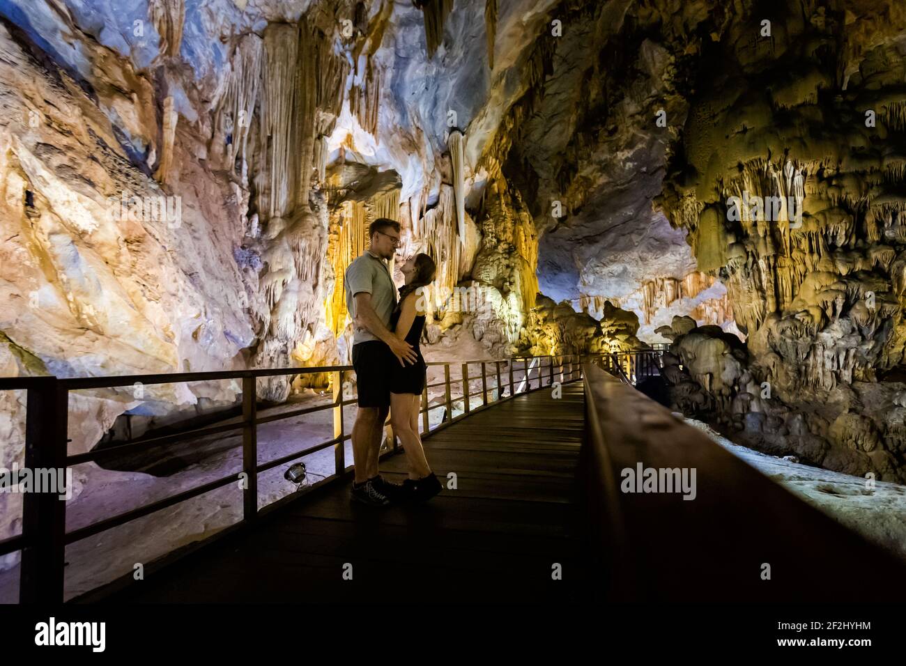 Happy married couple in Paradise Cave close to touristic Phong Nha in Vietnam. Underground rock formation photo taken in south east Asia. Stock Photo