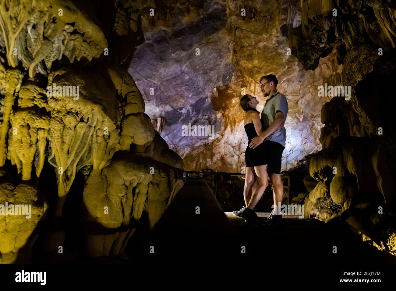 Happy married couple in Paradise Cave close to touristic Phong Nha in Vietnam. Underground rock formation photo taken in south east Asia. Stock Photo