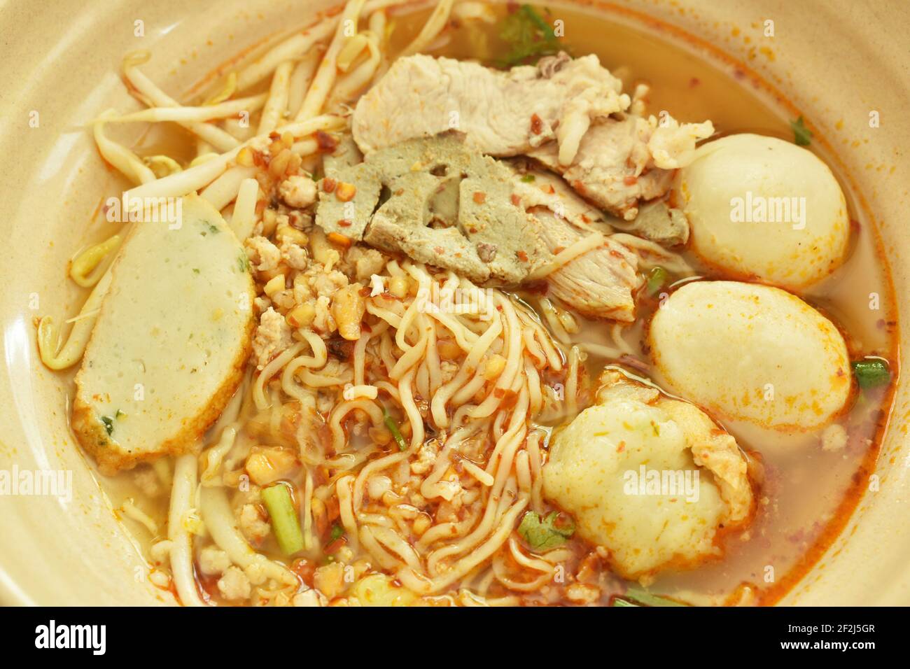 Chinese egg yellow noodles topping slice boiled pork and ball in spicy
