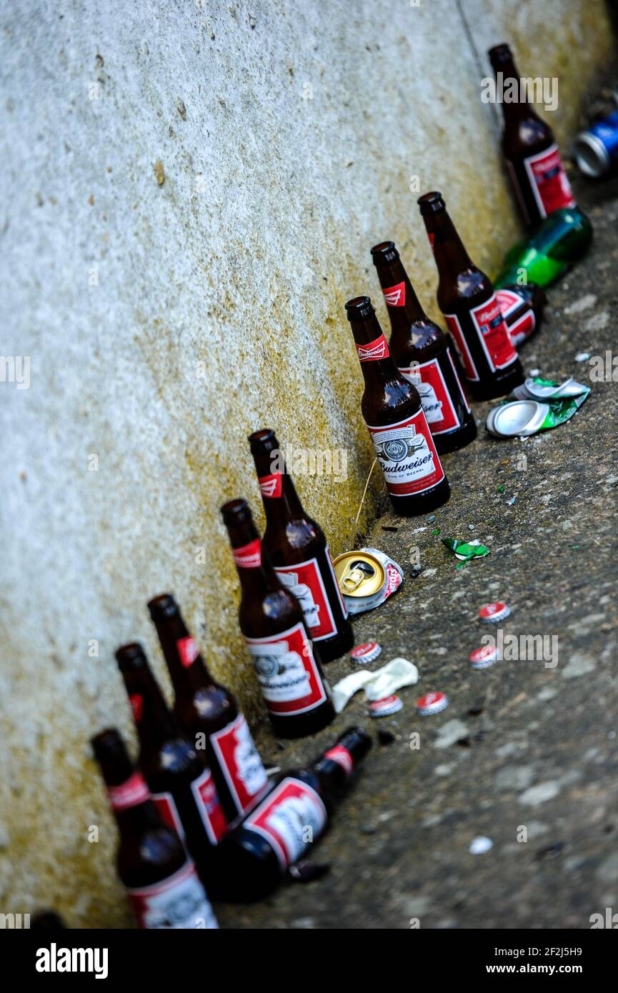 Empty brown beer bottles discarded in an alley way Stock Photo