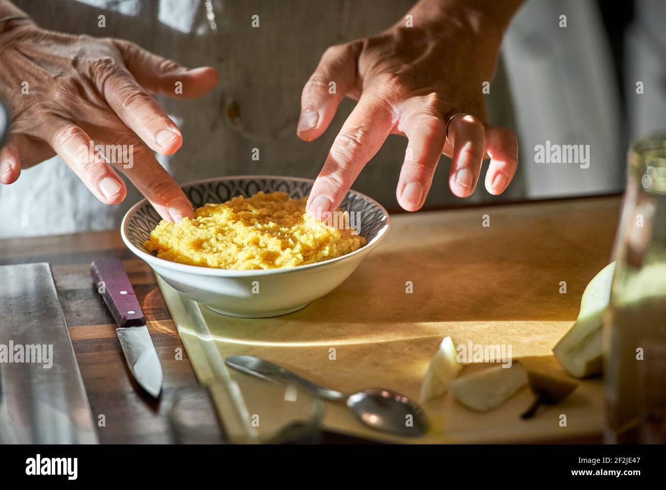 Woman's hands prepare polenta in a bowl Stock Photo