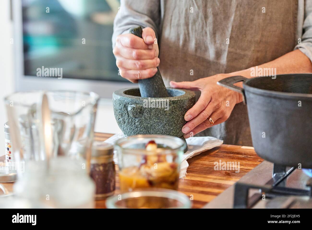 Hands of a woman crushing spices in a mortar Stock Photo