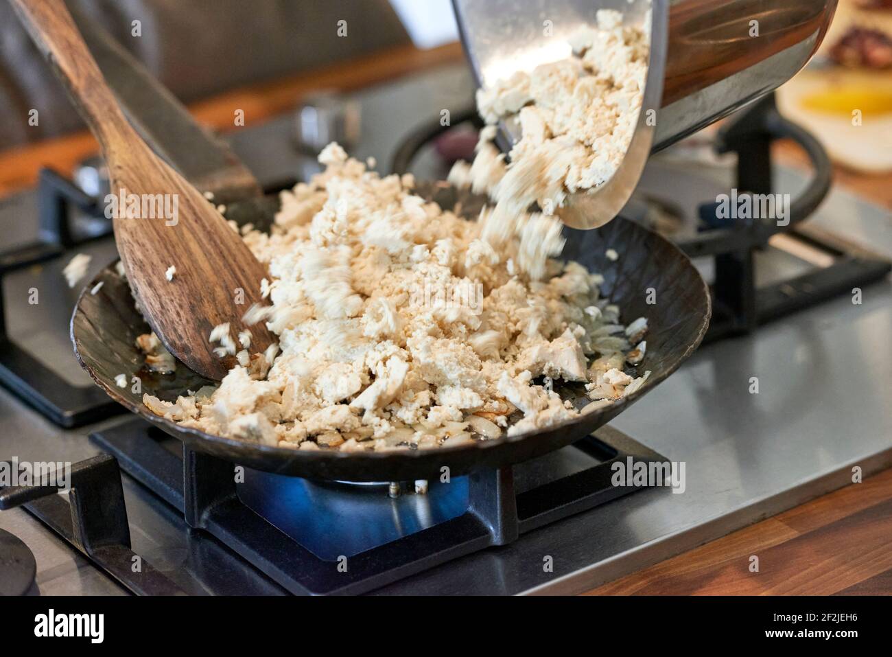 Tofu is filled and fried in a black iron pan on a gas stove Stock Photo