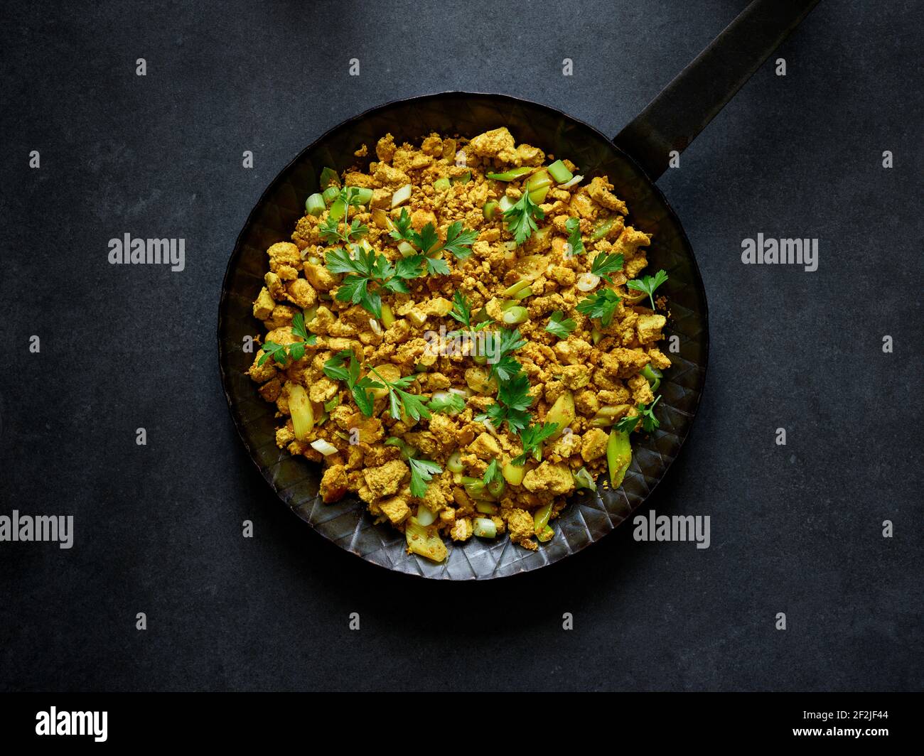 Supervision of Ayurvedic Scrambled Tofu in the iron pan Stock Photo