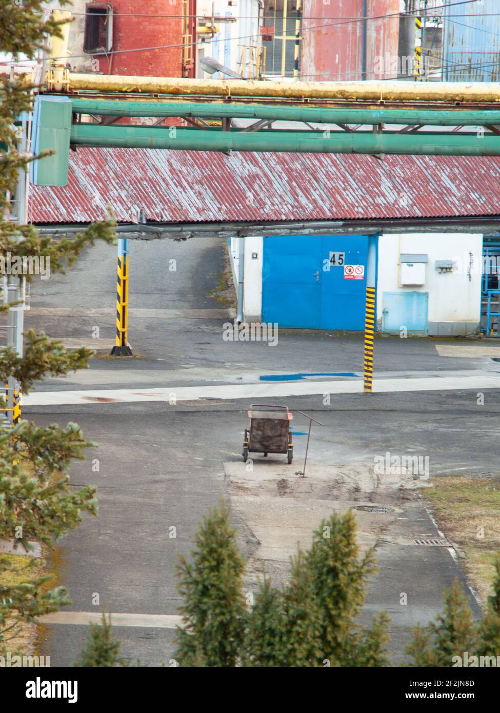 Yard of an old factory, a cart is abandoned in the middle, the company seems to be abandoned. Stock Photo