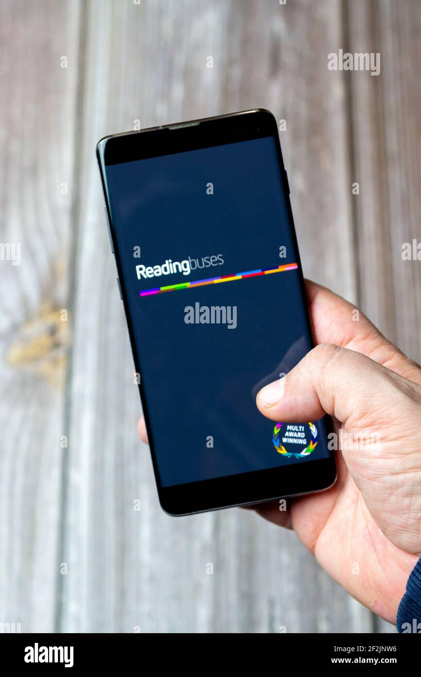 A Mobile phone or cell phone being held in a hand with the Reading bus app open on screen Stock Photo