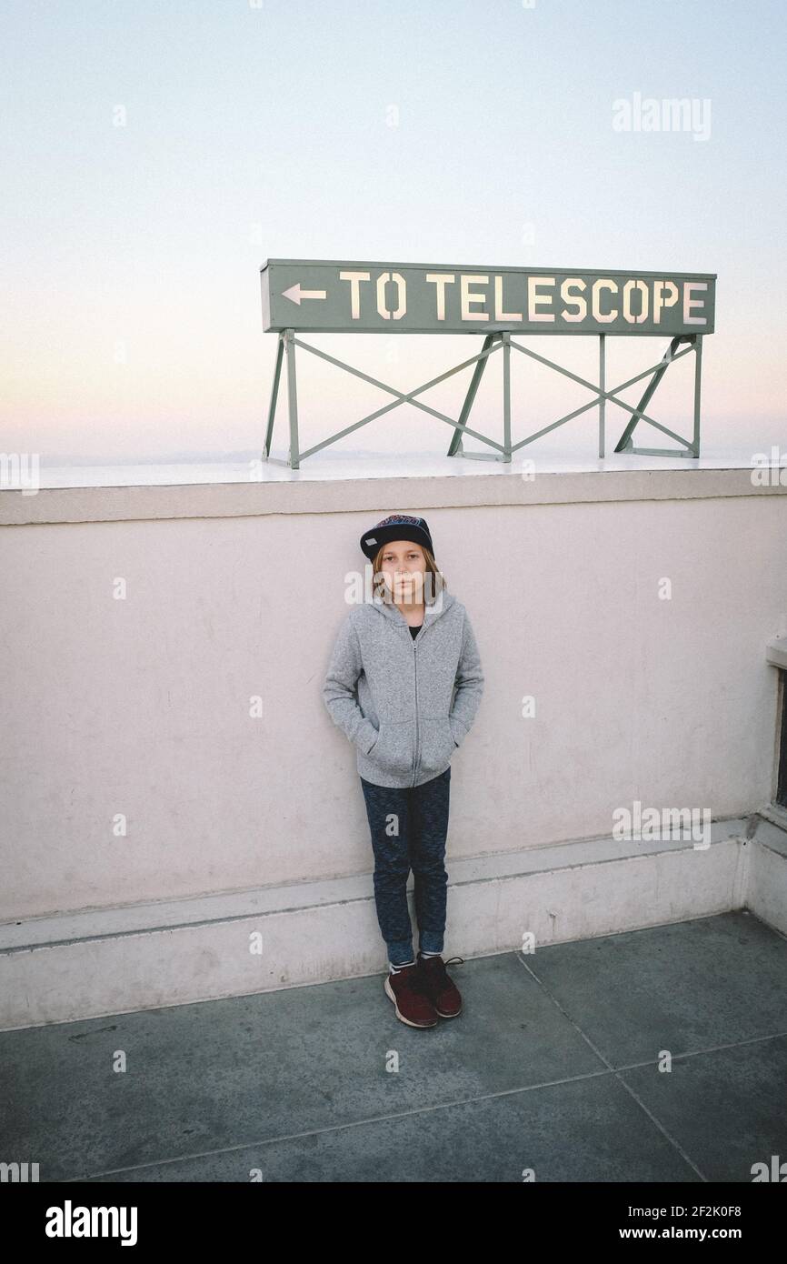 Boy Stands under Telescope Sign in Los Angeles Stock Photo