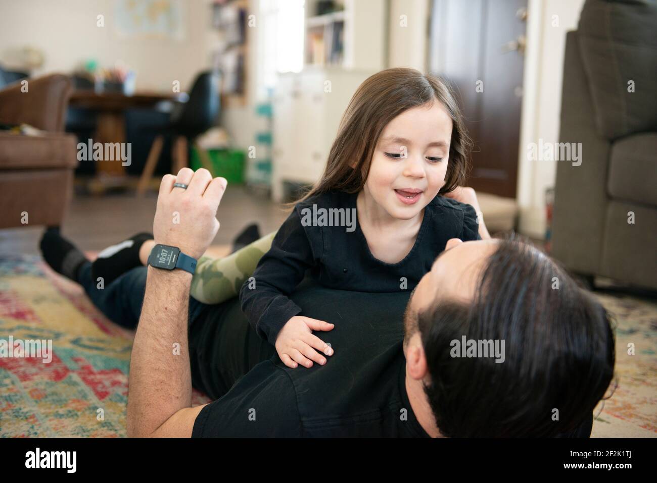Father and daughter playing on the floor. Stock Photo