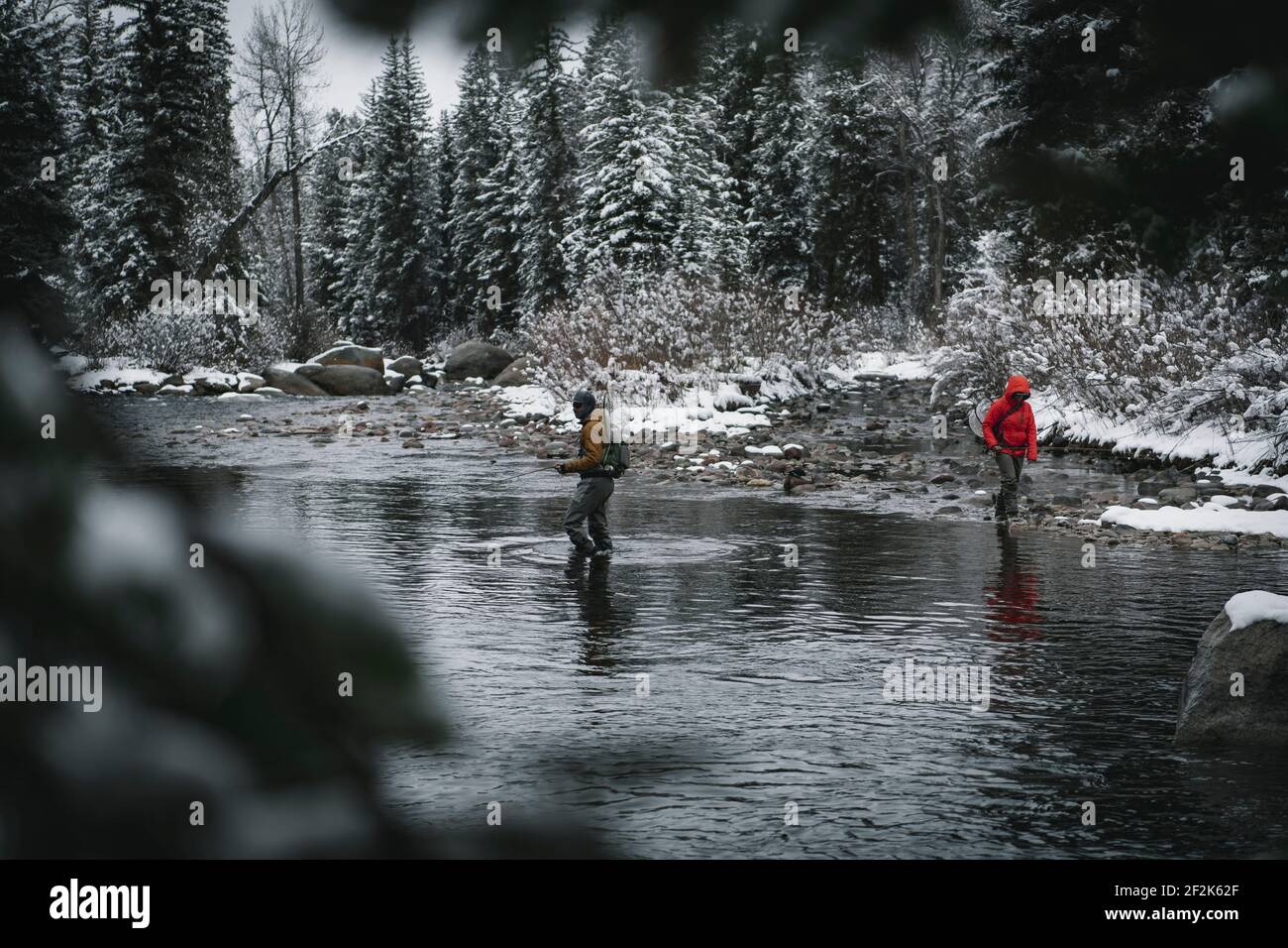 Man and woman walking in river while fly fishing in winter during vacation Stock Photo