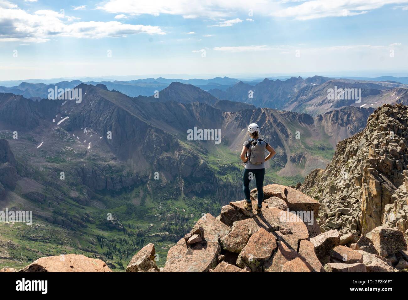 Rear view of woman looking at view while standing on mountain Stock Photo