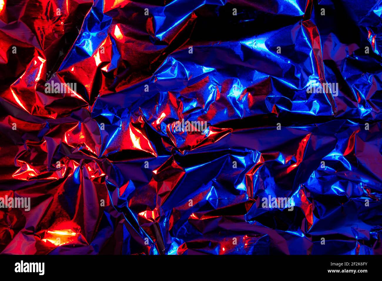 Abstract red and blue aluminum wrinkled foil background texture reflecting  red and blue light Stock Photo - Alamy