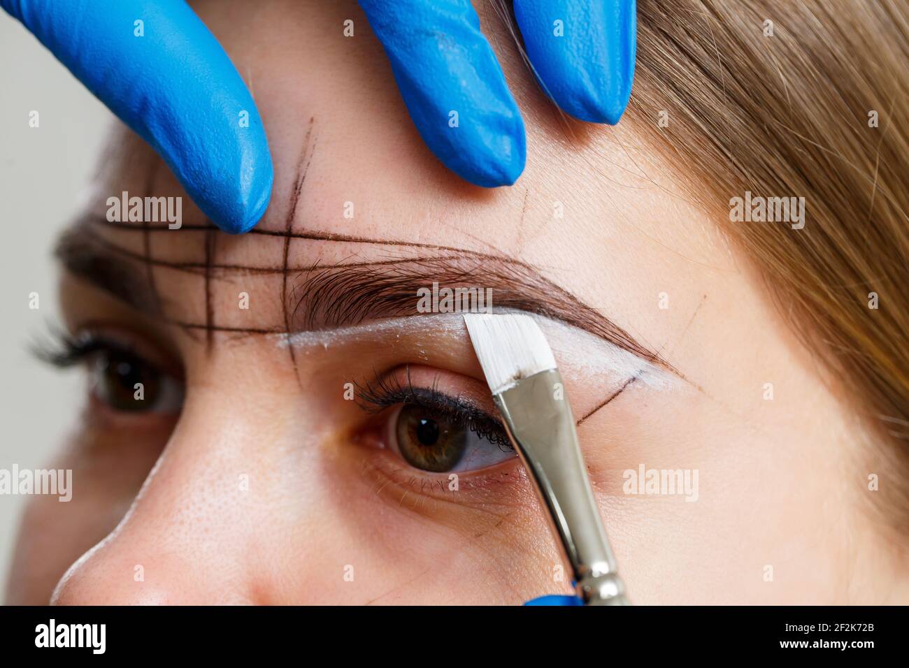 woman permanent makeup artist draws a sketch of the eyebrows on the face of her client Stock Photo - Alamy