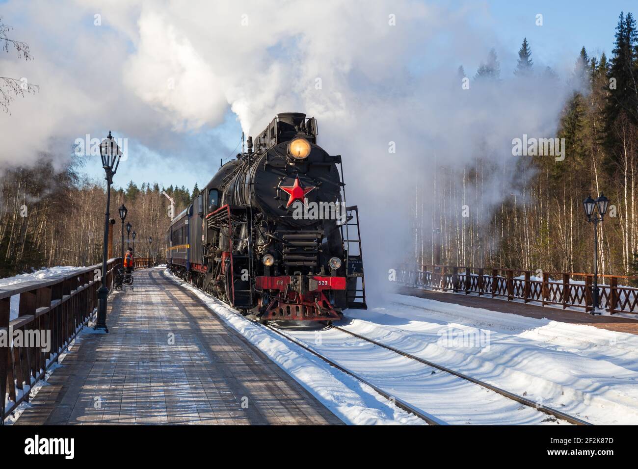 RUSKEALA, RUSSIA - MARCH 10, 2021: Tourist retro train Ruskeala Express on steam locomotive arrives at the station Gorny Park Ruskeala Stock Photo