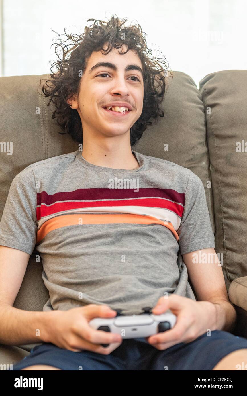 Male teenager playing with a PS5 Stock Photo