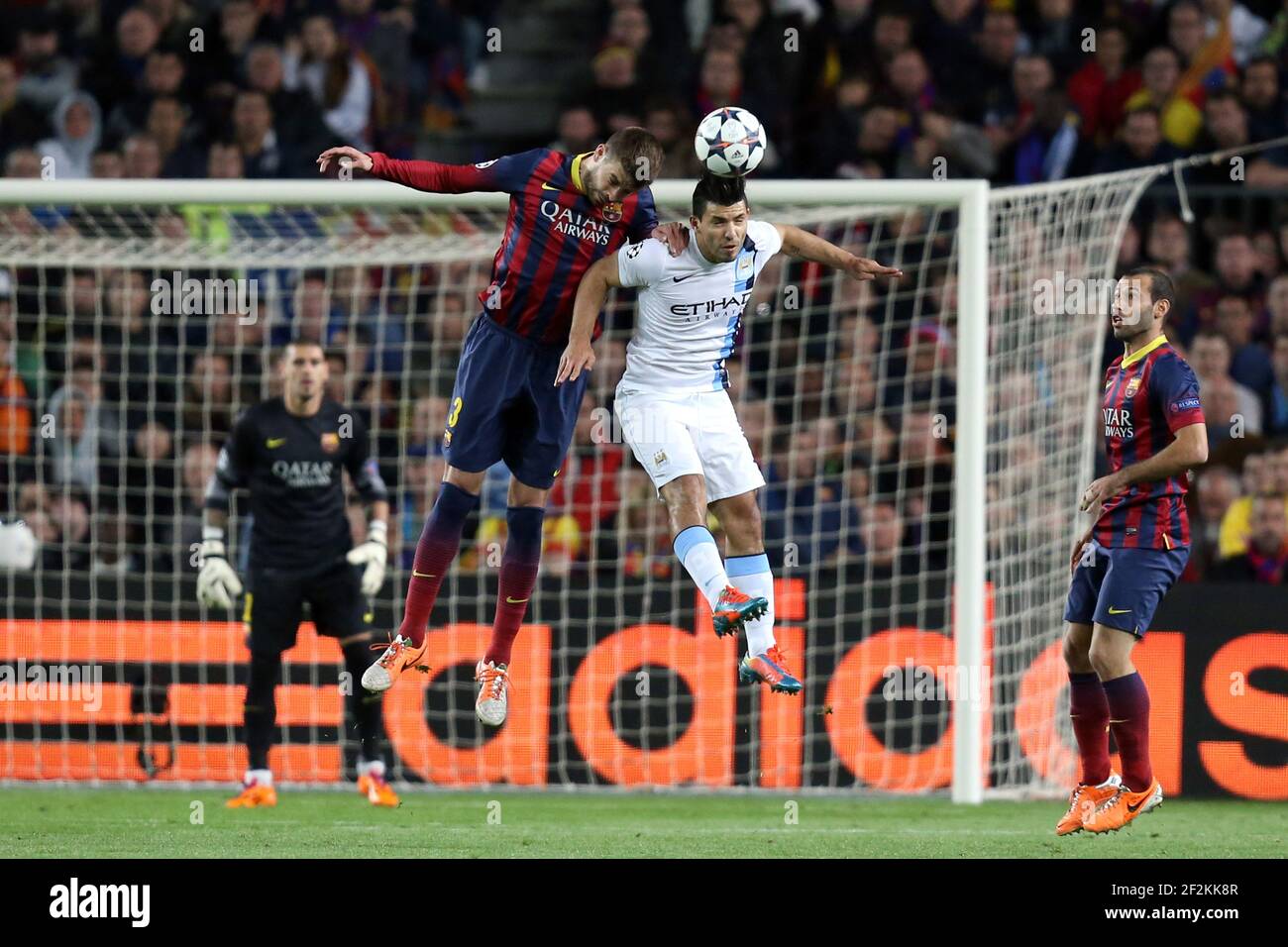 Football - UEFA Champions League 2013/2014 - 1/8 FINAL - 2nd Leg - FC Barcelona v Manchester city in Camp Nou Stadium of Barcelona on March 12 , 2014 in Barcelona , Spain - Photo Manuel Blondeau / AOP PRESS / DPPI - Sergio Aguero of Manchester City FC jumps to win a header with Gerard Pique of FC Barcelona Stock Photo