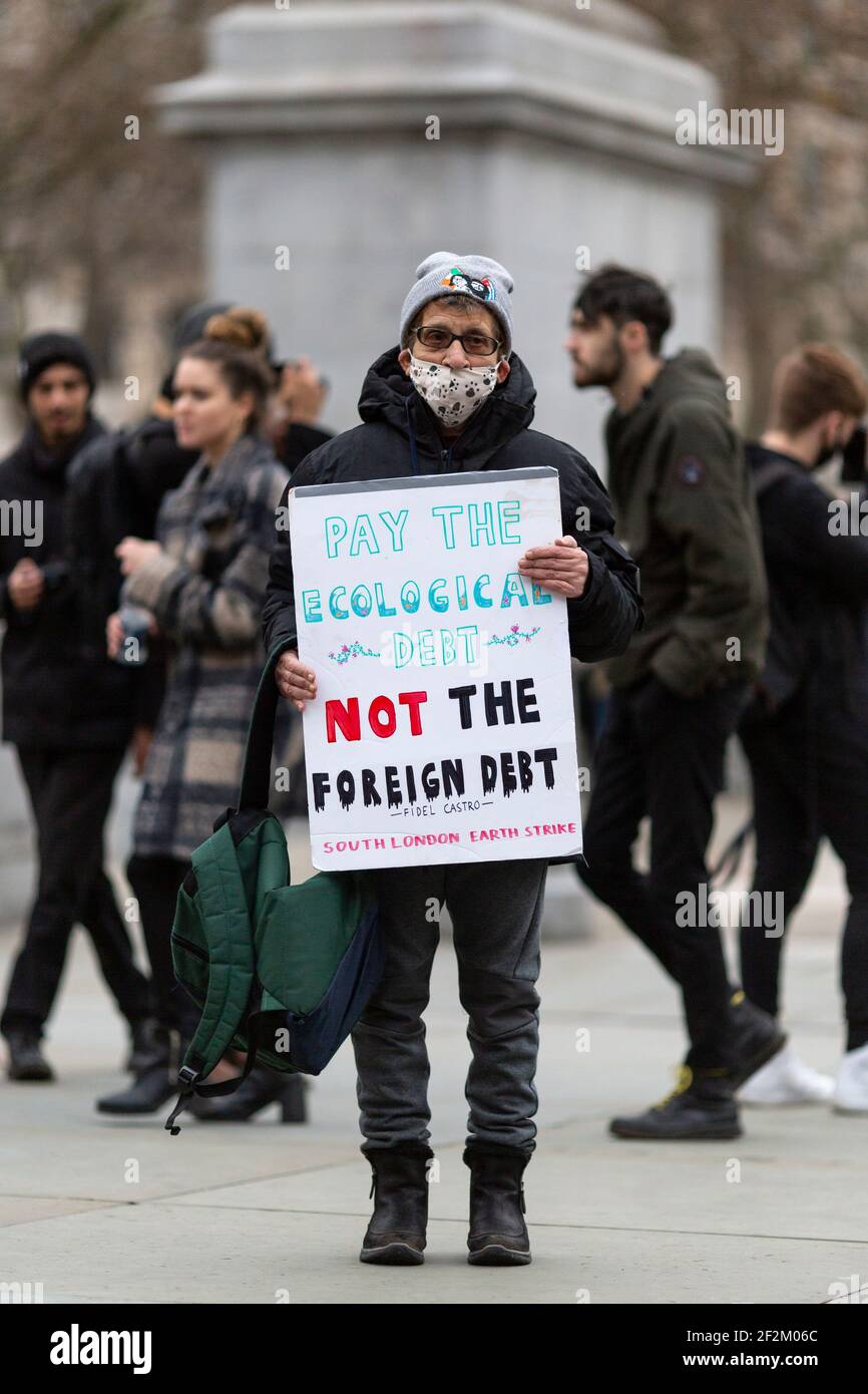 Portrait of Earth Strike protester with placard, at demonstration against US involvement in Cuba, Trafalgar Square, London, 12 December 2020 Stock Photo