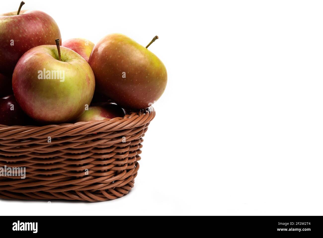 Wicker basket of fresh juicy apples isolated on white background Stock Photo