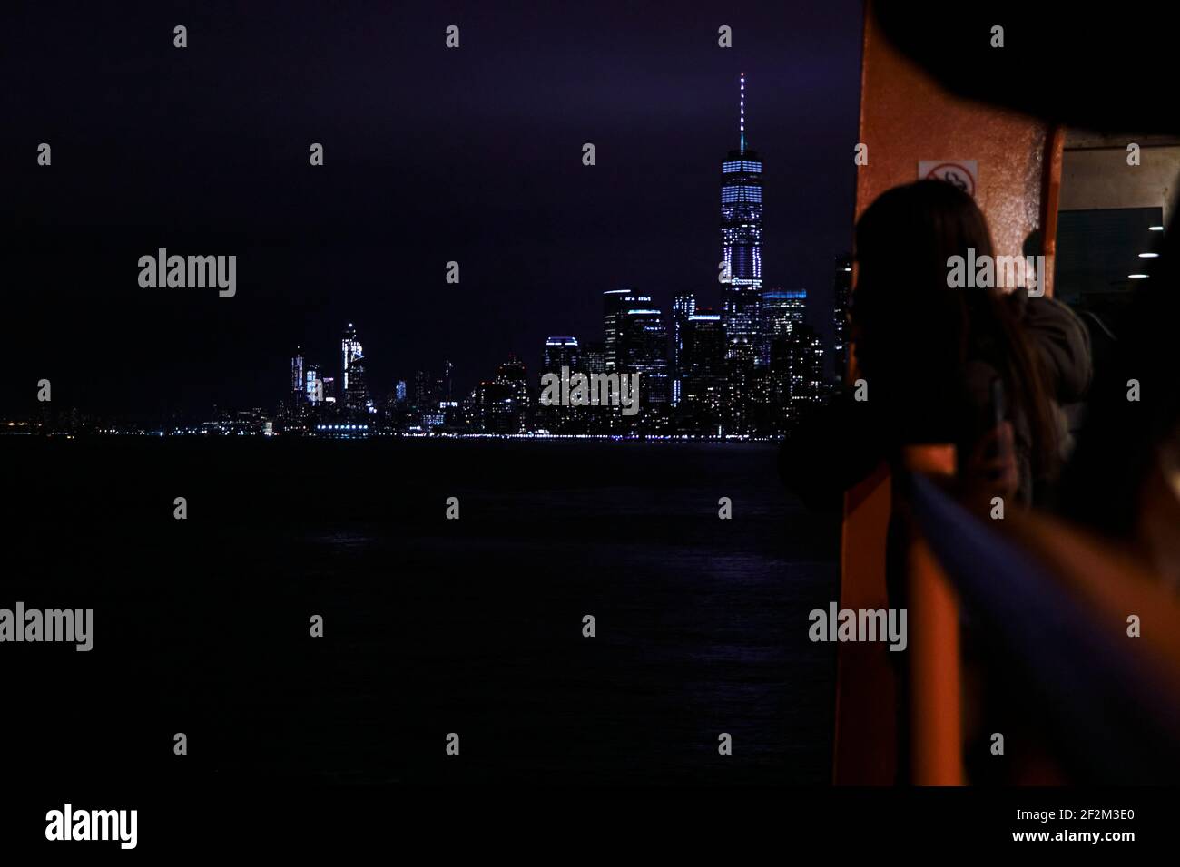 View from Staten Island Ferry at cityscape and Skyline of Manhattan at night, New York, USA, United States of America, Stock Photo