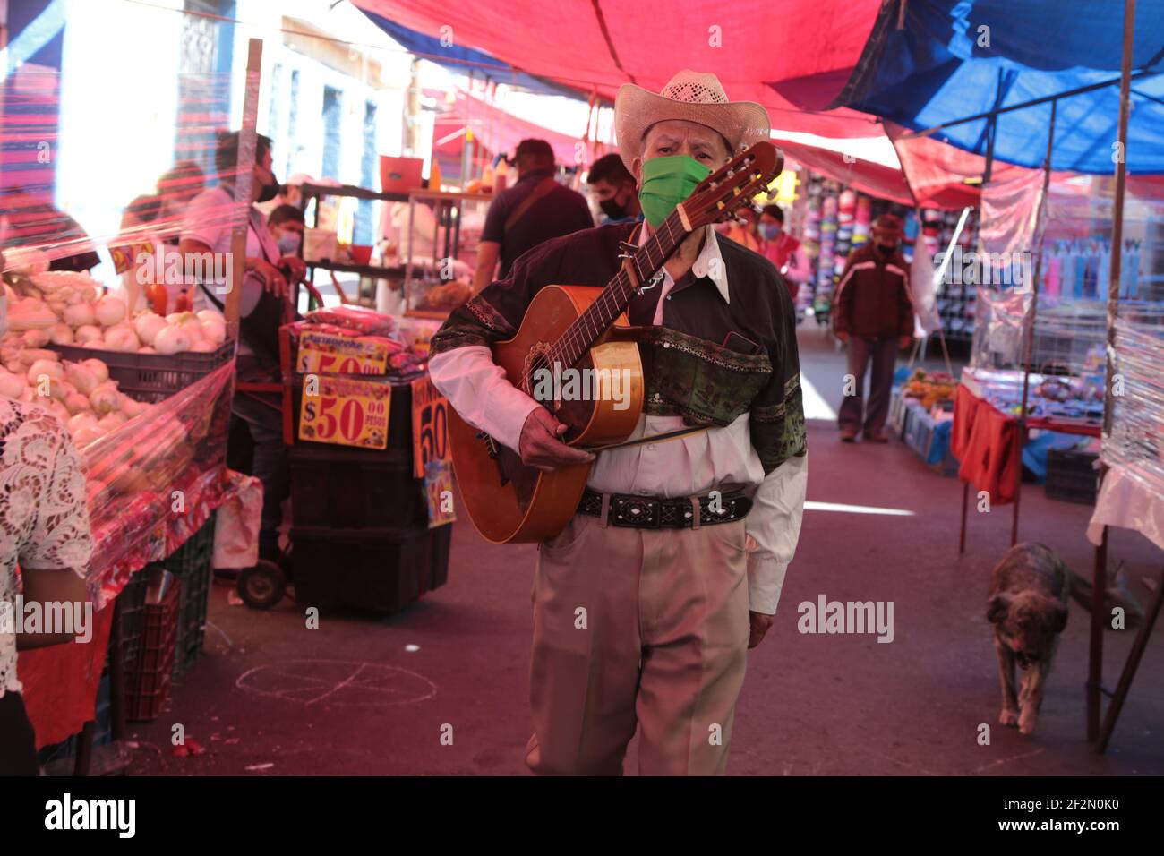 MEXICO CITY, MEXICO - MARCH 12: A musician walks in an outdoor market amid Orange Epidemiological semaphore of Covid-19. Authorities has allowed the reopening of outdoor markets, following safety protocols. On March 12, 2021 in Mexico City, Mexico. (Photo by Eyepix/Sipa USA) Stock Photo